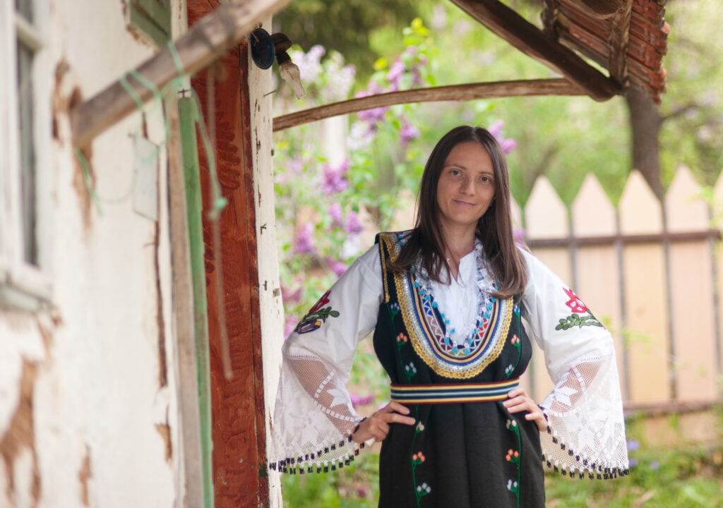 Een jonge vrouw poseert in traditionele Servische handgemaakte kleding