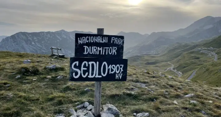 Bergen met bord met de tekst Sedlo op 1907 meter hoogte in Nationaal Park Durmitor