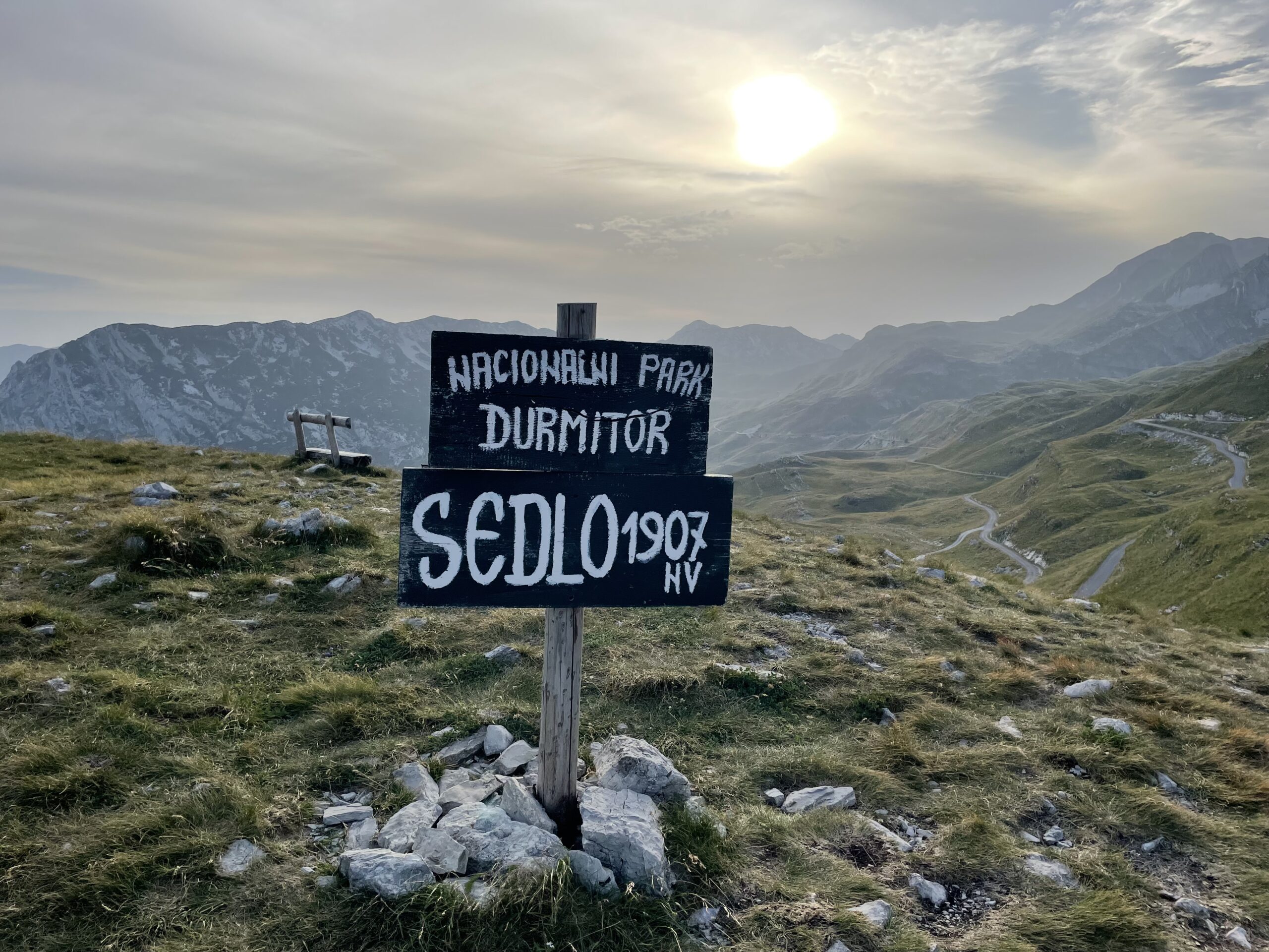 Bergen met bord met de tekst Sedlo op 1907 meter hoogte in Nationaal Park Durmitor