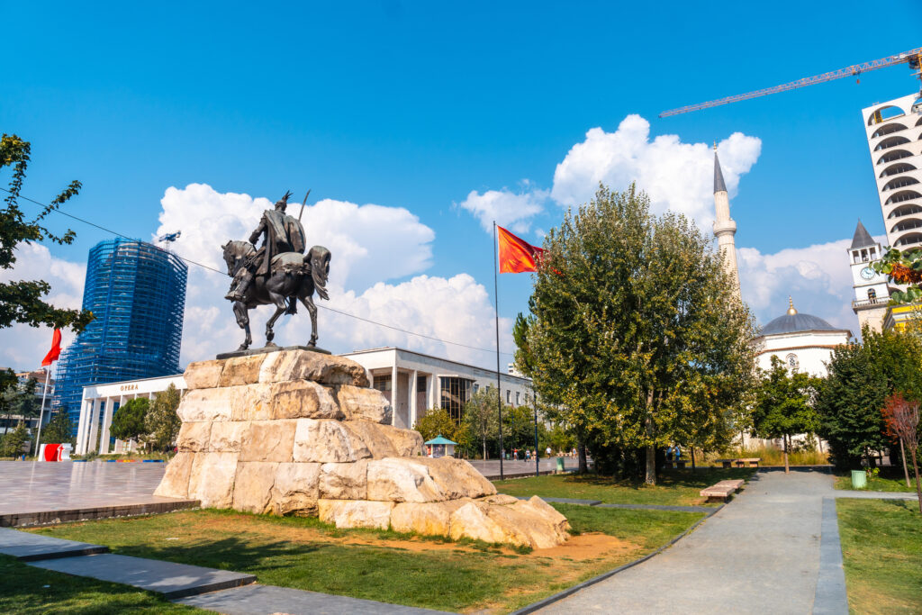 Skanderbeg paardenmonument op het Skanderbeg plein in Tirana en de rode vlag van Albanië