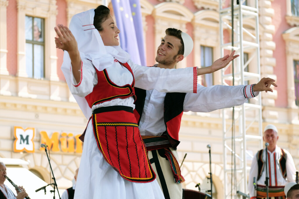 Man en vrouw in kleding van Kosovo tijdens dansvoorstelling