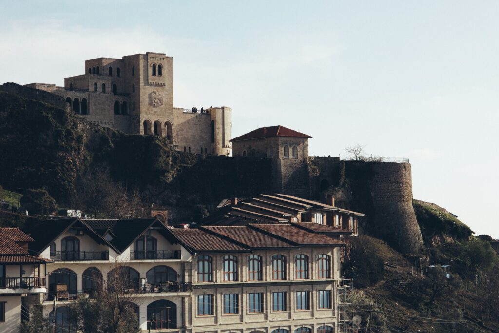 Een kasteel op de top van een heuvel naast een gebouw in Krujë in Albanië