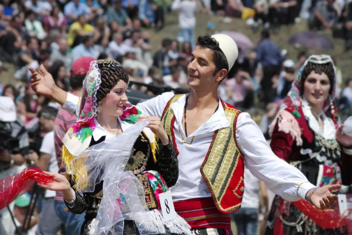 Man en vrouw dansen in Albanië met traditionele Albanese kleding